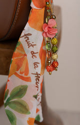 Decorative ribbon with floral design and beads on a neutral background