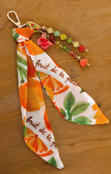 Fabric keychain with fruit pattern on a wooden surface