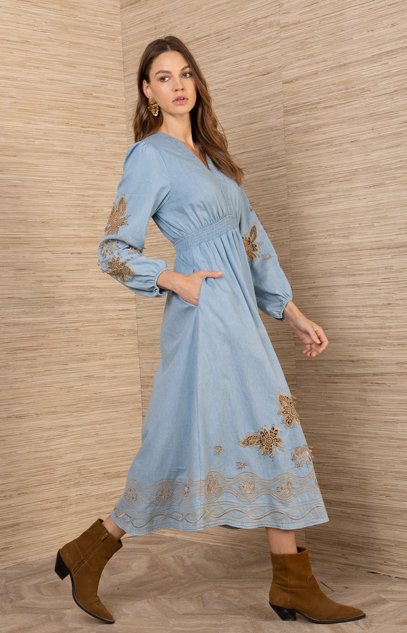 Paulina Embroidered Dress, color_Navy

Woman wearing a light blue dress with floral embroidery against a wooden wall.