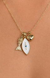 A gold chain necklace with three charms worn on a person's neck: a gold fish charm, a white teardrop-shaped charm with gold detailing and a small blue stone, and a small gold heart charm.